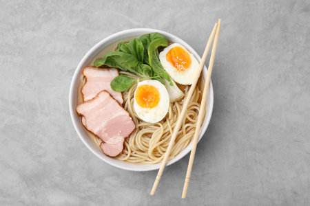 Delicious ramen with meat on light gray table, top view. Noodle soupの写真素材