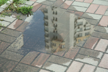 Puddle after rain on street tiles outdoorsの写真素材