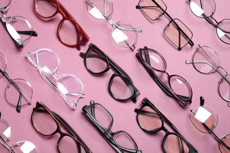 Different stylish glasses on pink background, flat lay