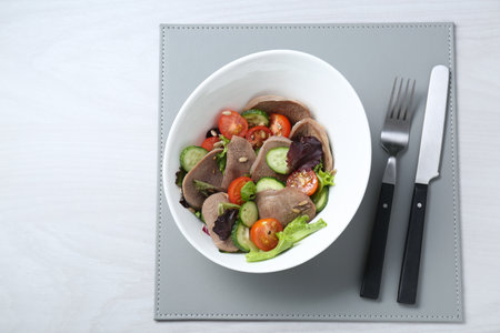 Delicious salad with beef tongue and vegetables served on white wooden table, flat lay. Space for textの写真素材
