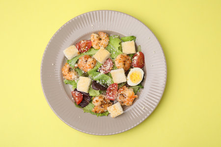 Delicious Caesar salad with shrimps on yellow background, top viewの写真素材