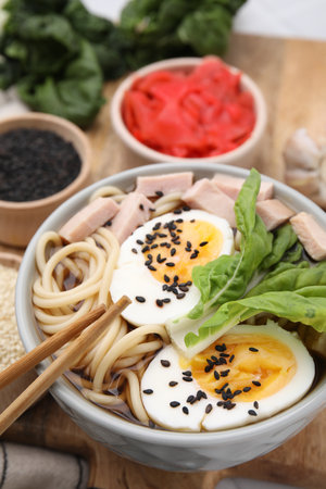 Bowl of delicious ramen with meat and egg on wooden board, closeup. Noodle soupの写真素材