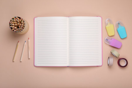 Open planner and stationery on beige background, flat lay. Space for textの写真素材