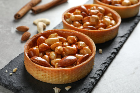 Tartlets with caramelized nuts on light gray table, closeup. Tasty dessertの写真素材