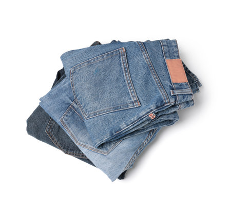 Stack of different folded jeans isolated on whiteの写真素材