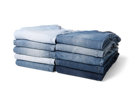 Stacks of different folded jeans isolated on whiteの写真素材