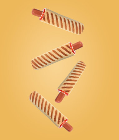 Yummy French hot dogs with grilled buns falling on goldenrod backgroundの写真素材