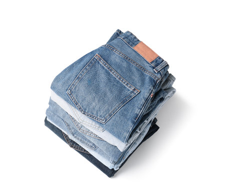 Stack of different folded jeans isolated on whiteの写真素材