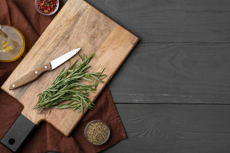 Wooden board, knife and spices on gray table, flat lay. Space for textの写真素材