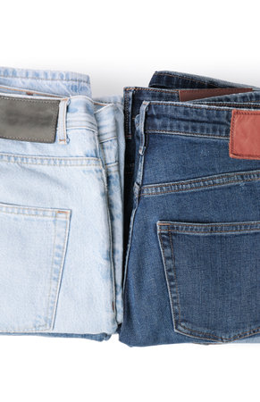Stacks of different folded jeans isolated on white, top viewの写真素材