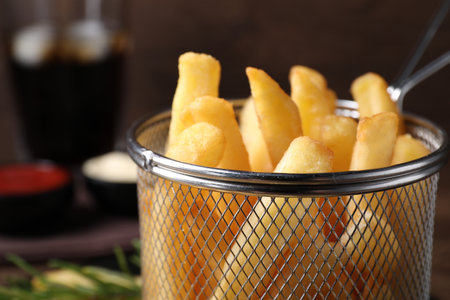 Delicious French fries in metal basket, closeup. Space for textの写真素材