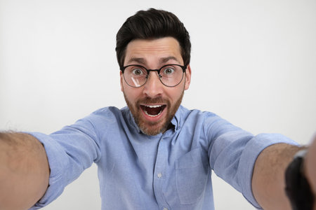 Smiling man taking selfie on white backgroundの写真素材