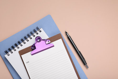 Mini clipboard with to do notes, planner, notebook and pen on beige background, flat lay. Space for textの写真素材