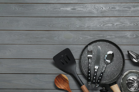 Set of kitchen utensils on dark gray wooden table, flat lay. Space for text