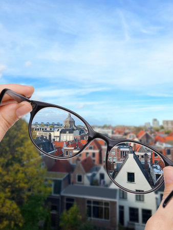 Vision correction. Woman looking through glasses and seeing cityscape clearerの写真素材