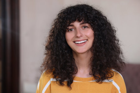 Portrait of happy young woman in stylish sweater indoors