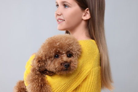 Little child with cute puppy on light gray background. Lovely petの写真素材