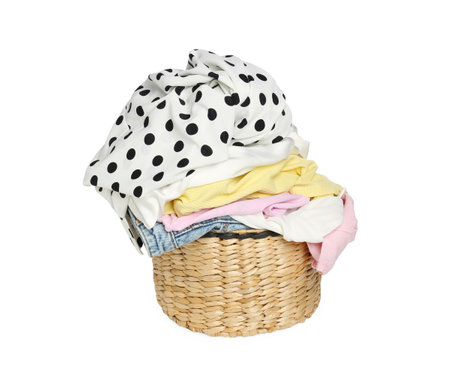 Wicker laundry basket with clean colorful clothes isolated on whiteの写真素材