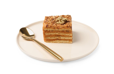 Piece of delicious layered honey cake and spoon on white backgroundの写真素材