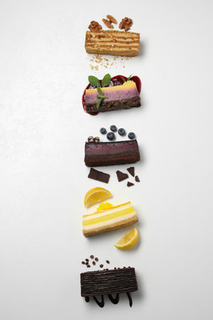 Flat lay composition with different tasty cakes on light table