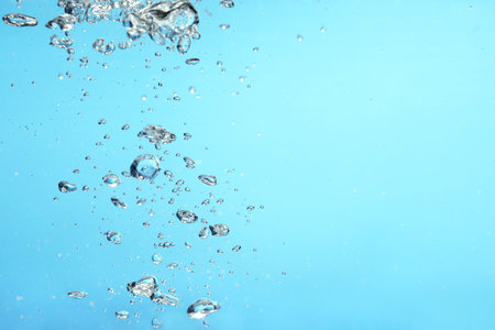 Air bubbles in water on light blue background. Space for textの写真素材