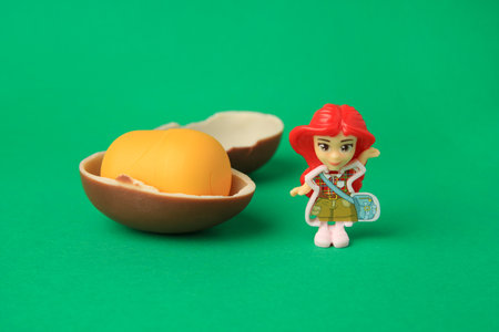 Slynchev Bryag, Bulgaria - May 25, 2023: Halves of Kinder Surprise Egg, plastic capsule and toy on...
