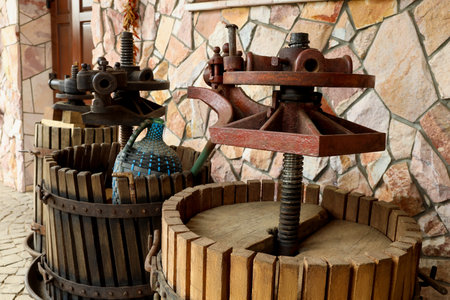 Metal winepresses in wooden barrels near stone wallの写真素材