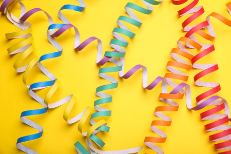Rainbow serpentine streamers on yellow background, flat lay. LGBT prideの写真素材