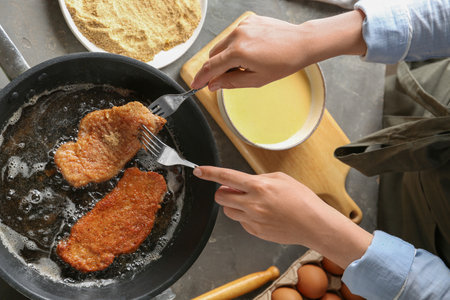 Woman cooking schnitzels in frying pan, top viewの写真素材