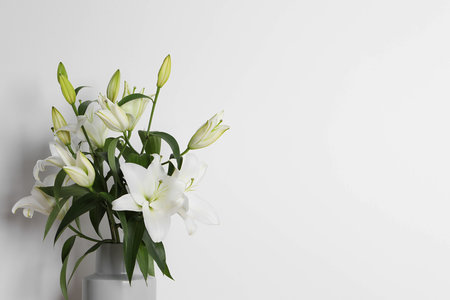 Beautiful bouquet of lily flowers in vase on white background, space for textの写真素材