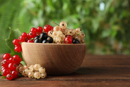 Different fresh ripe currents on wooden table outdoors, closeup. Space for textの写真素材