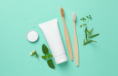 Flat lay composition with bamboo toothbrushes and herbs on turquoise backgroundの写真素材