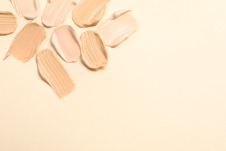 Samples of skin foundation on beige background. Space for textの写真素材