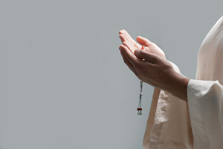 Muslim man with misbaha praying indoors, closeup. Space for textの写真素材