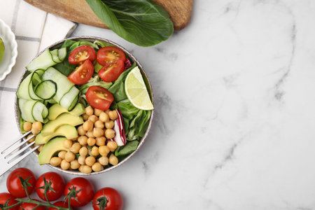 Tasty salad with chickpeas and vegetables served on white marble table, flat lay. Space for textの写真素材
