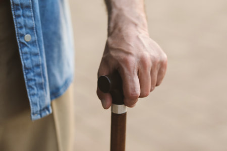 Senior man with walking cane outdoors, closeupの写真素材