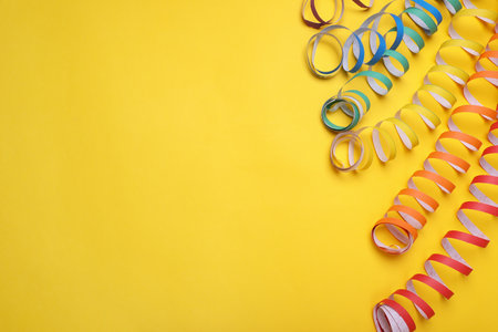 Rainbow serpentine streamers on yellow background, flat lay with space for text. LGBT prideの写真素材