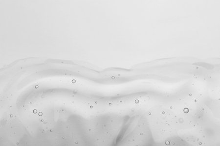 Sample of cosmetic oil on light surface, top view. Space for text