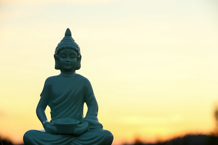 Decorative Buddha statue outdoors at sunset. Space for textの写真素材