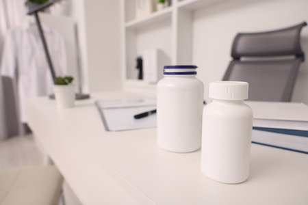 Plastic medical bottles on white table, space for text. Doctor's workplaceの写真素材