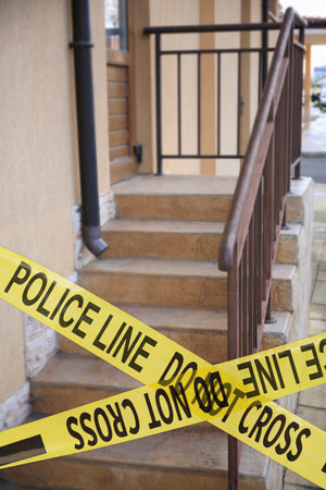 Yellow crime scene tape blocking way to stairs outdoorsの写真素材