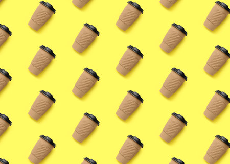 To-go drink. Pattern design with paper coffee cup on light yellow backgroundの写真素材