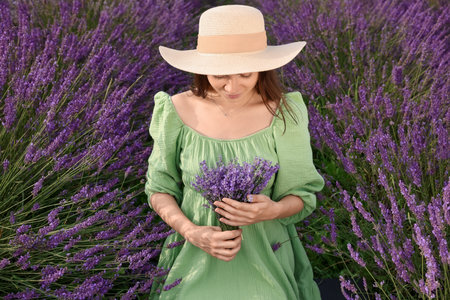 Beautiful woman with bouquet in lavender fieldの写真素材