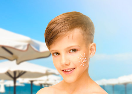 Sun protection. Boy with sunblock on his face on beachの写真素材