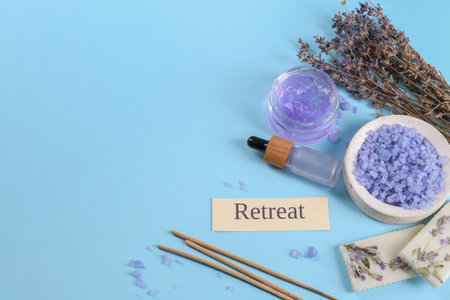 Retreat concept. Composition with card, dried lavender flowers and different spa products on light blue background, space for textの写真素材
