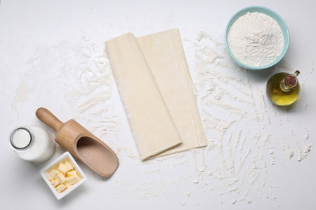 Fresh dough and different ingredients for making baklava on white table, flat layの写真素材