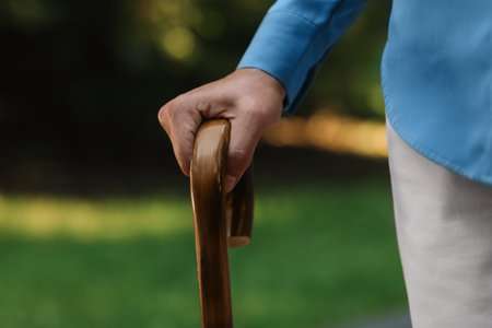 Senior woman with walking cane outdoors, closeupの写真素材