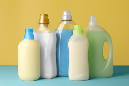 Bottles of fabric softener on light blue tableの写真素材