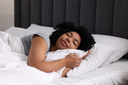 Beautiful young woman sleeping in soft bedの写真素材