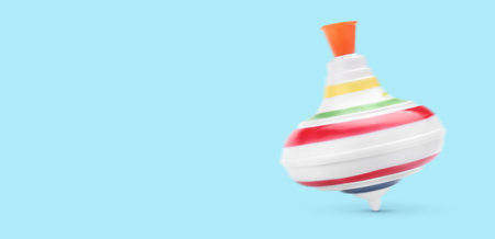One spinning top in motion on light blue background, banner design with space for text. Toy...
